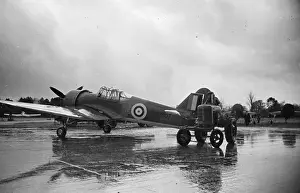 Prints of 10th January 1942: AZ607, a Miles Master II advanced trainer aircraft for the RAF, with a tractor used to tow it on the factory airfield. Other uncompleted examples are in the background Discover the Vision of Haywood Magee – A Master of Mid-Century British Life: Miles Master