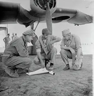 Military Men Going over Bombing Mission Near Aircraft