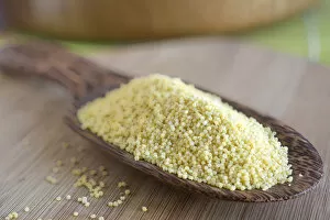 Millet grains on a wooden scoop made of coconut wood