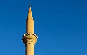 Minaret of a mosque protruding into the blue sky, Goreme, Cappadocia, Turkey