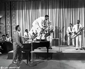 Prints of CIRCA 1957: Musician Little Richard performs onstage with his band as his saxophone player Grady Gaines stands on the piano in circa 1957 in scene from the movie Mister Rock And Roll The Architect of Rock: Mister Rock And Roll Film Still