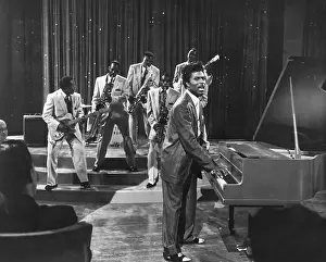 Prints of CIRCA 1957: Musician Little Richard performs onstage with his band as his saxophone player Grady Gaines stands on the piano in circa 1957 in scene from the movie Mister Rock And Roll The Architect of Rock: Mister Rock And Roll Film Still