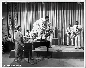 Prints of CIRCA 1957: Musician Little Richard performs onstage with his band as his saxophone player Grady Gaines stands on the piano in circa 1957 in scene from the movie Mister Rock And Roll The Architect of Rock: Mister Rock And Roll Movie Still