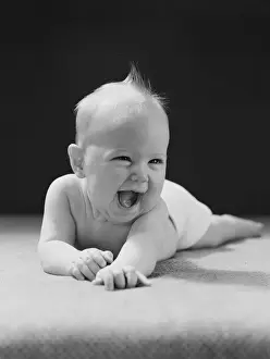 0 11 Months Prints: Five month old baby lying on stomach, arms outstretched, laughing