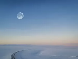Moon over snowy road, Iceland
