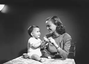 Mother with baby (6-9 months) playing at home, (B&W)