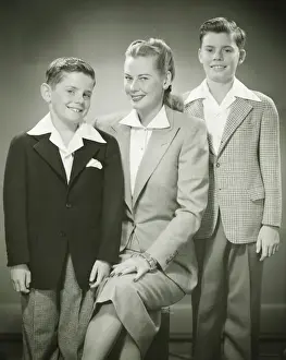 10 11 Years Prints: Mother with brothers (8-9) (10-11) sitting in studio, smiling, (B&W), portrait