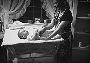Changing Gallery: Mother changing babys (3-6 months) nappy, (B&W)