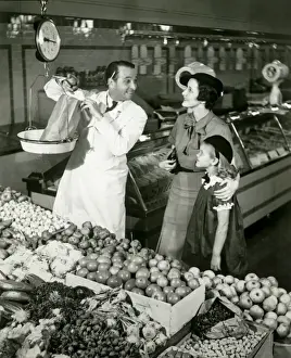 Groceries Prints: Mother and daughter in supermarket, shop assistant weighing groceries