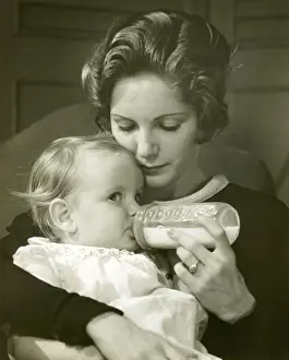 Mother feeding baby girl