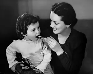Mother giving medicine to daughter
