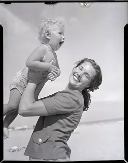 Lifting Prints: Mother Lifting Smiling Toddler at the Beach