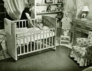 One Parent Prints: Mother looking at baby (3-6 months) lying in crib, (B&W)