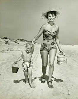 30 35 Years Prints: Mother with son (2-3) walking on beach, (B&W), portrait