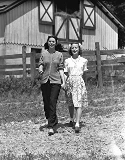 Arm In Arm Gallery: Mother with teenage daughter(13-14) walking on field in front of barn