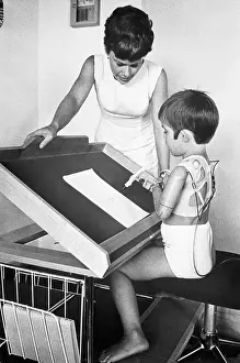 Thalidomide Prints: Mother Watches Child Write with False Limbs