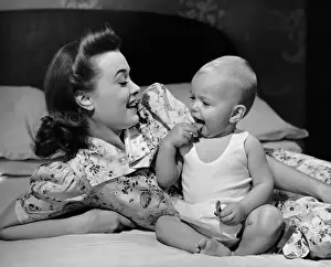 Mother watching baby eat cookie