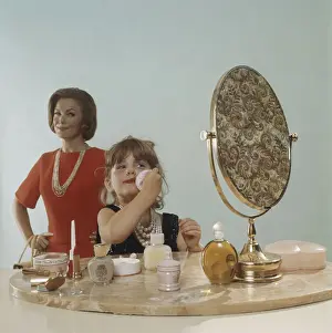 Coloured Background Prints: Mother watching daughter applying make-up