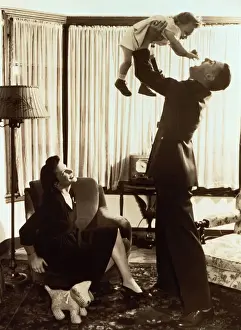 Mother watching father lifting toddler (18-21 months) (B&W sepia tone)