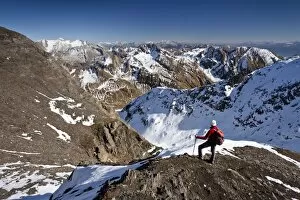 Mountain climber on the summit ridge while descending from Wilde Kreuzspitze Mountain in the Pfunderer Mountains
