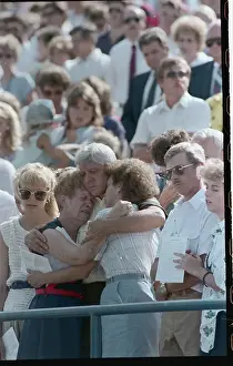Mournful Family Members Embracing at Memorial