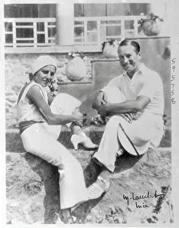 Mr. and Mrs. Maurice Chevalier Sitting by Sidewalk
