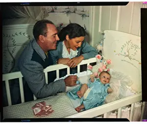 Pat Obrien Prints: Mr. and Mrs. Pat O'Brien Talking to Baby in Crib