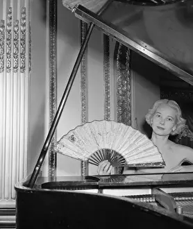 Guest Prints: Mrs. Winston Guest Sitting at Piano and Holding Large Fan