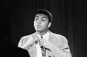 Prints of (Original Caption) 3/24/1964-New York, NY- Heavyweight champion Cassius Clay adjusts his tie as he appears on a CBS-TV news program A photo tribute to the boxing legend: Muhammmad Ali Adjusting Tie