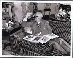 Multi Talented Cecil Beaton Reading While Poised on His Couch