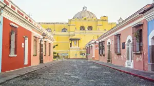 Convent Prints: Multicolored street of Antigua, La Merced Church on background