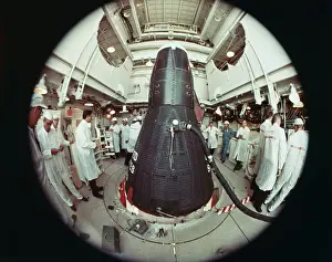 NASA Technicians Working by a Space Capsule