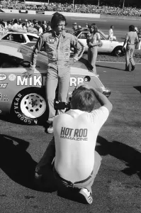 Prints of DAYTONA BEACH, FLORIDA - JULY 1980: A photographer for Hot Rod Magazine takes a picture of NASCAR driver Dale Earnhardt Sr Chasing Speed: Motorsport in Motion: NASCAR races and drivers