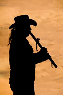 Navajo in silhouette playing flute