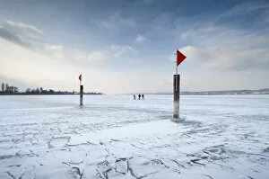 Incidental People Collection: Navigation mark on a frozen Lake Constance with skaters, island auf Reichenau, Konstanz district