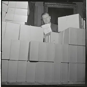 Nelson Rockefeller Reading from Large Stack of Reports