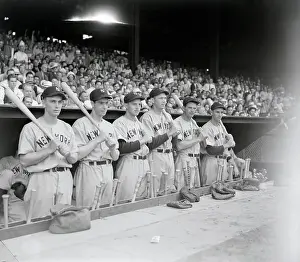 The New York Yankees Holding Bats Standing on Dugout
