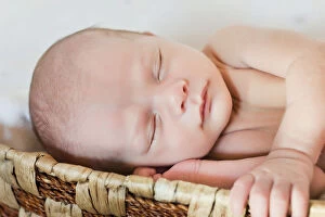Newborn baby, 3 weeks, sleeping in a basket