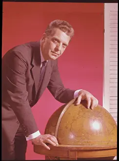 Newscaster Chet Huntley Leaning on Globe
