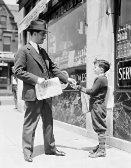 Images Dated 30th June 2008: Newspaper boy selling paper to businessman, Philadelphia
