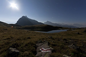 Marking Gallery: Night shot, full moon over Lake Berglimattsee with illuminated tent and sign post, Glarus Alps