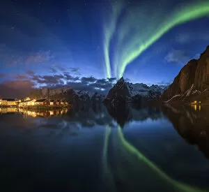 Northern Lights Collection: Northern lights over fishing village with mountain range on coastline at Hamnoy