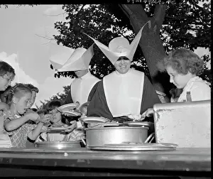 Two Nuns Serve Food to Children