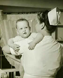 6 11 Months Prints: Nurse holding baby boy (6-12 months), (B&W)