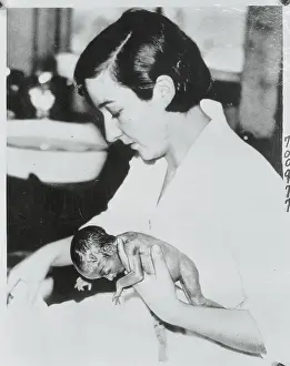 Nurse Holding Infant Quintuplet