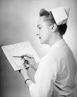 Nurse noting on patients chart, (B&W)