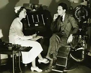 Eyesight Prints: Nurse talking to patient in opticians examination room, (B&W)