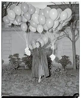 Odette Laure Holding Cluster of Balloons