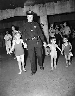 Officer Leads Three Children at Coney Island