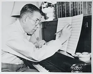 Ogden Nash Writing Lyrics onto Sheet of Music